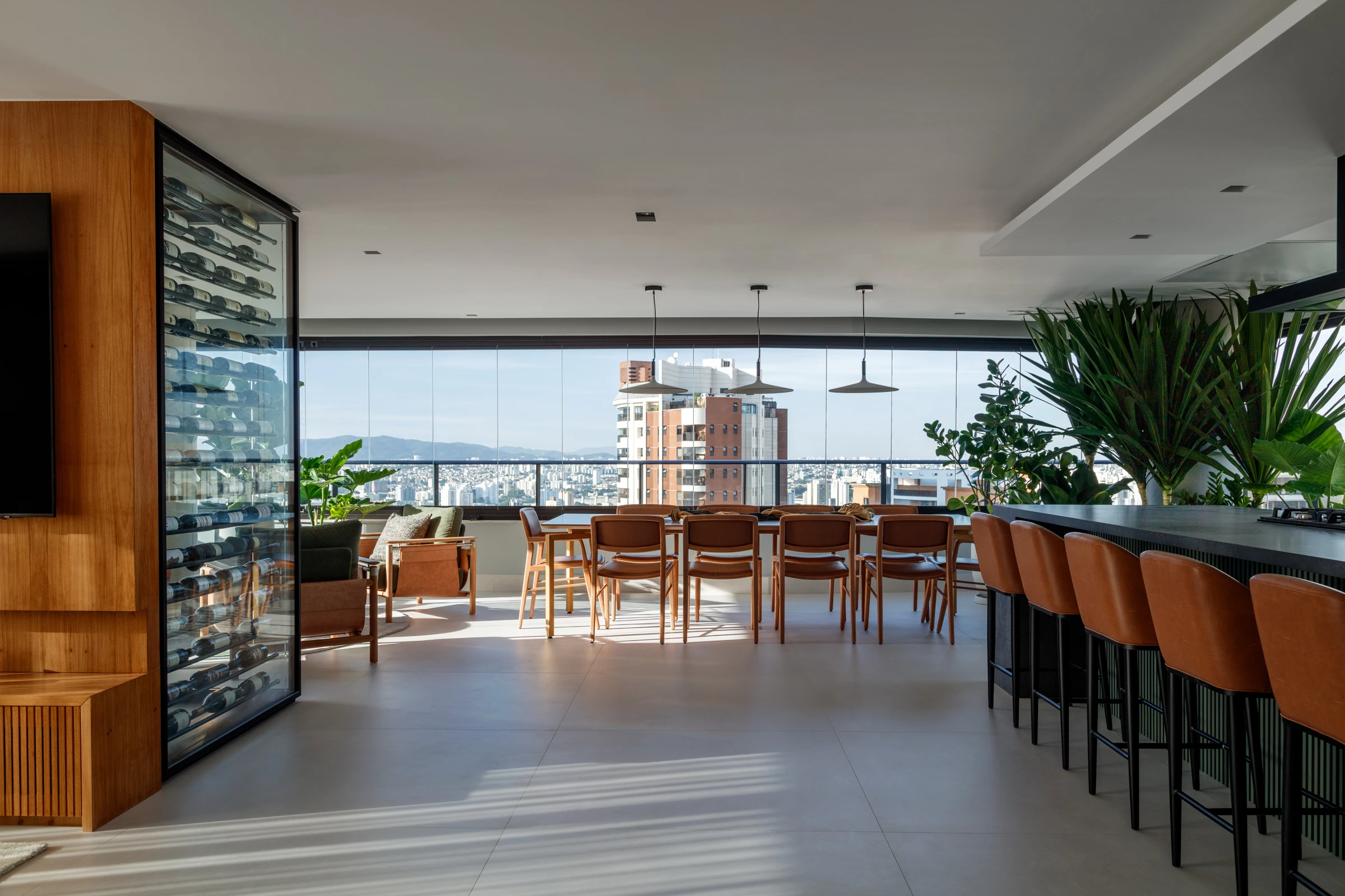 Varanda do Apartamento Alto de Pinheiros, com mesa de jantar, adega e bancada integrada